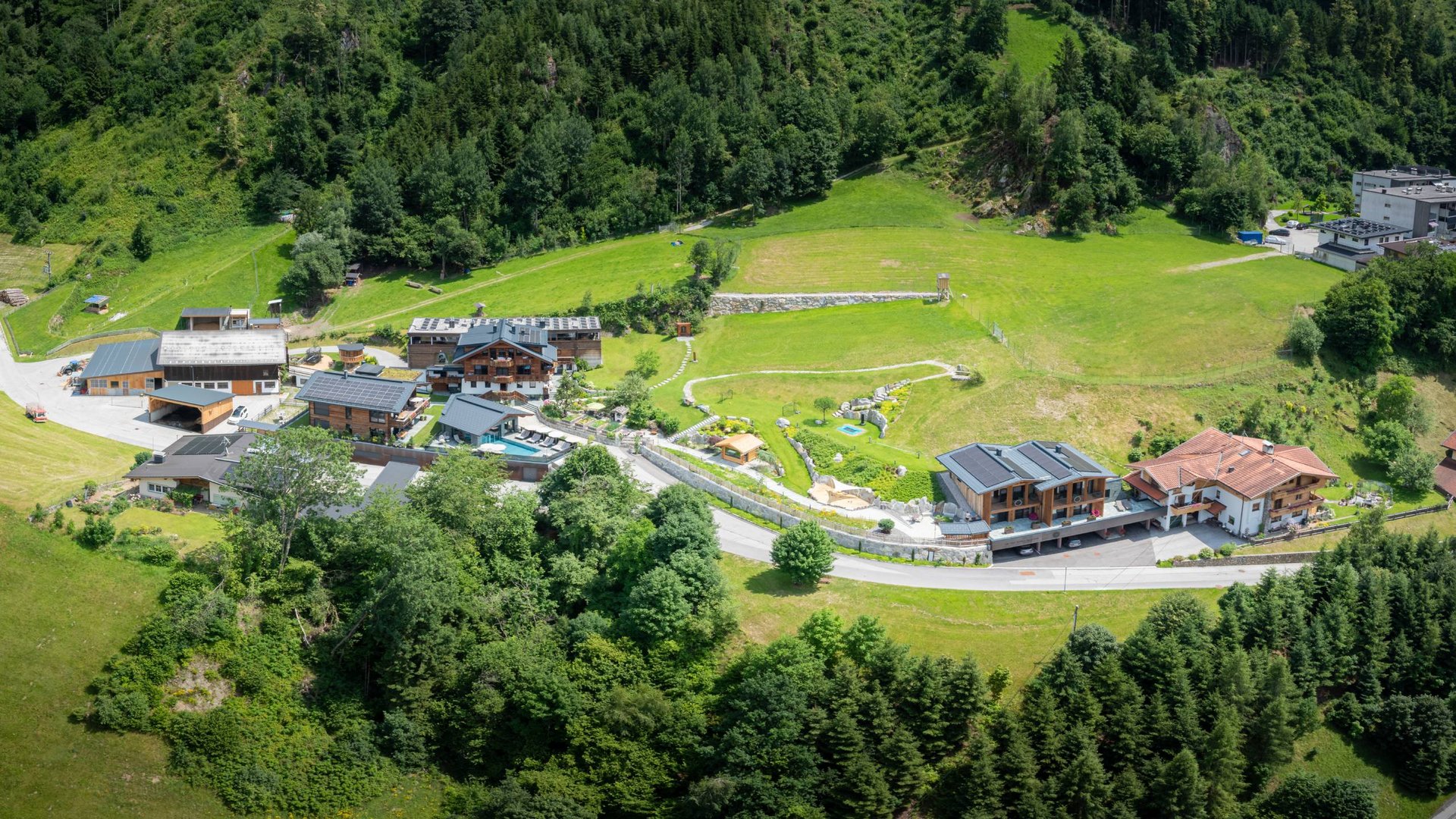 Apartment near Zell am Ziller? Your farmhouse holiday home. Aerial view of a small village with houses and green meadows in the forest