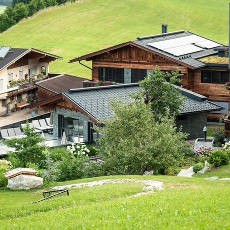 Sommer im Zillertal für die ganze Familie Moderne Ferienhäuser mit Solarpaneelen in grüner Hügellandschaft