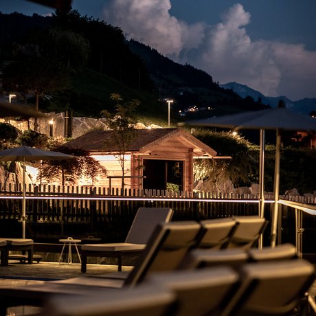 Sommer im Zillertal für die ganze Familie Beleuchtete Liegestühle und Holzhütte bei Nacht in den Bergen